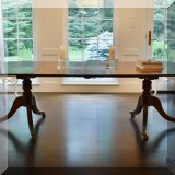 F27. Double pedestal dining table with brass lion claw feet. Includes 2 leaves measuring 21”each. 28”h x 50”w x 47”w 